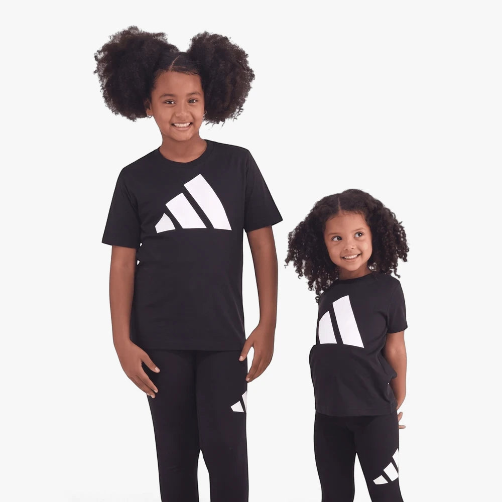 Two young girls wearing black Adidas Kids Short Sleeve Tees and matching pants, featuring the white Adidas logo.