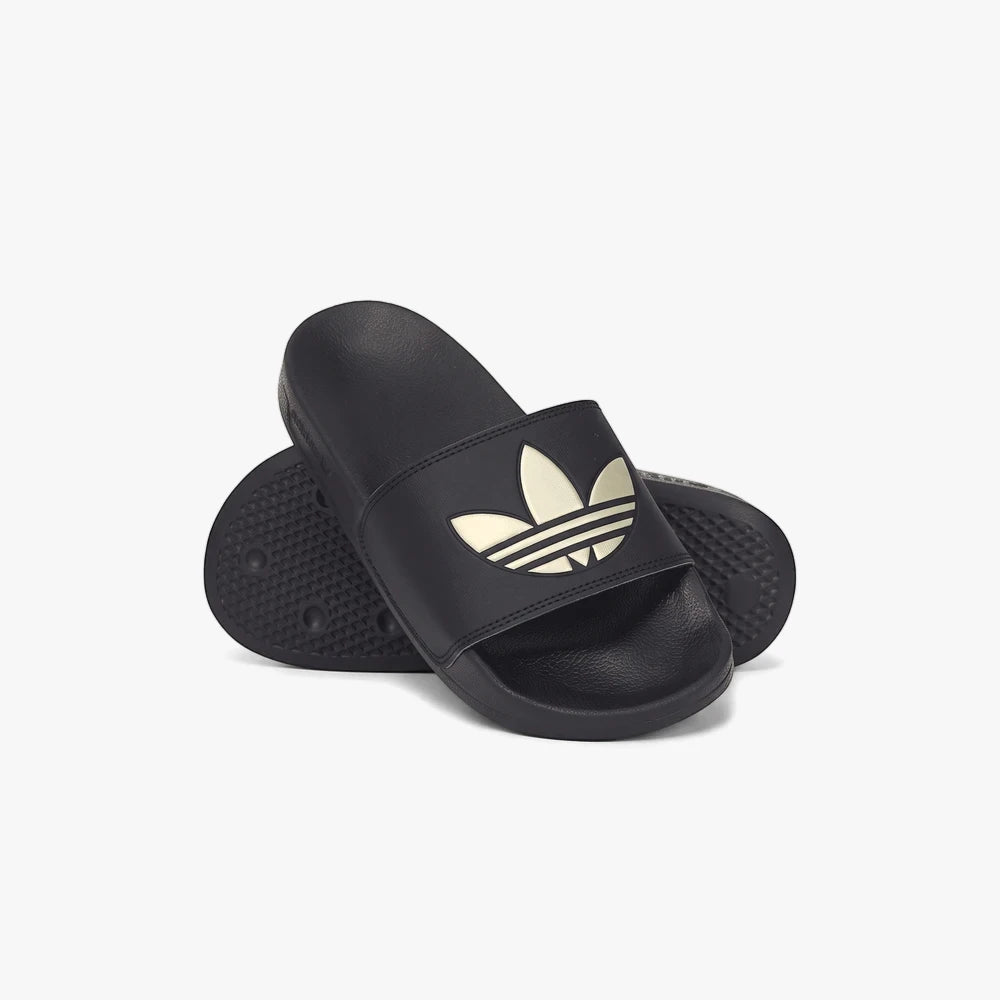 A pair of black Adidas Womens Adilette Lite Slides with a gold trefoil logo, casually arranged on a surface, offering