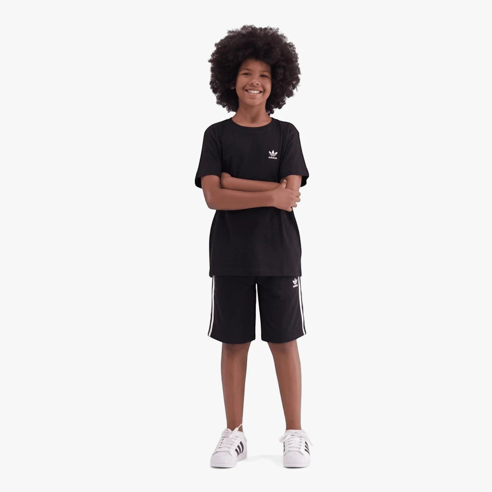 Young boy wearing a black Adidas Youth Ess Short Sleeve Tee and black Adidas shorts with white stripes, with white Adidas