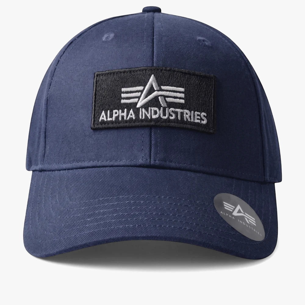 Alpha Industries Bedge Peak Cap in navy featuring a black embroidered patch with logo, curved brim and adjustable fit