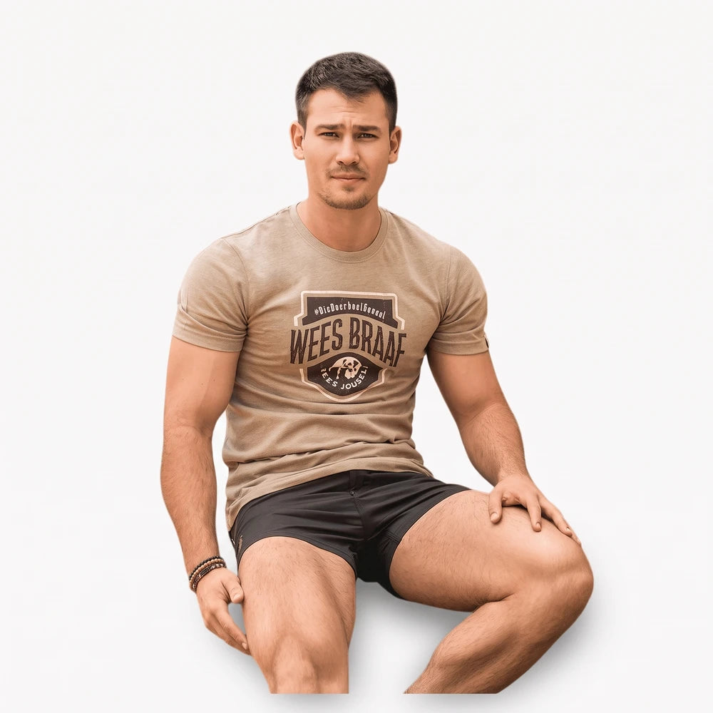 Boerboel Mens Premium Cotton Braaf Short Sleeve Tee in sand, featuring a shield logo, worn by a man in dark shorts.