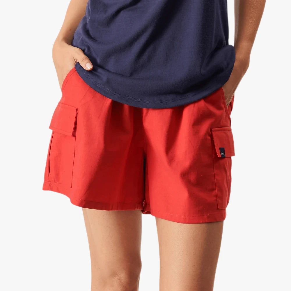 Close-up of a woman wearing red Fox Flip Side Cargo Shorts, featuring practical side pockets, captured from the waist down.