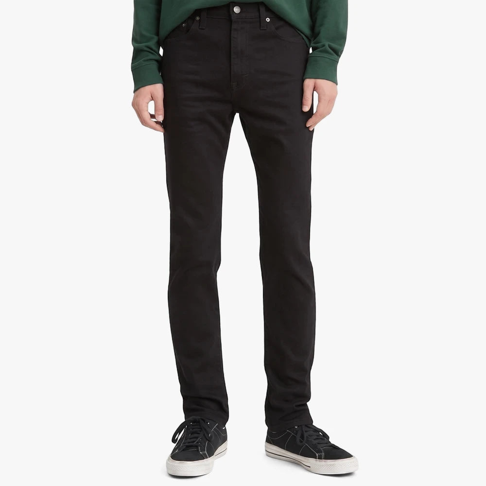 Full body shot of a man wearing Levis Mens 510 Skinny Stretch Jeans in Native Cali black, paired with a green shirt and