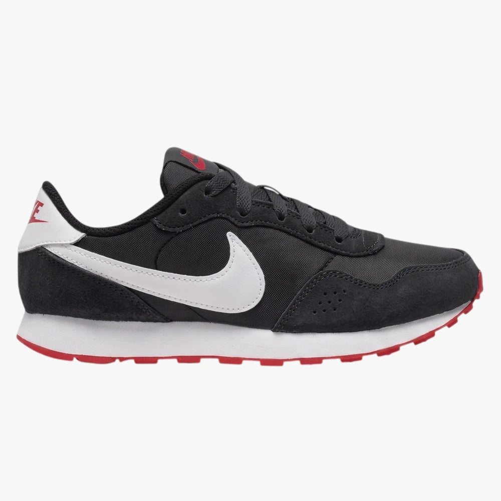 Nike Girls Md Valiant Sneaker in black with white swoosh, white midsole, and red outsole, shown from a side profile view.