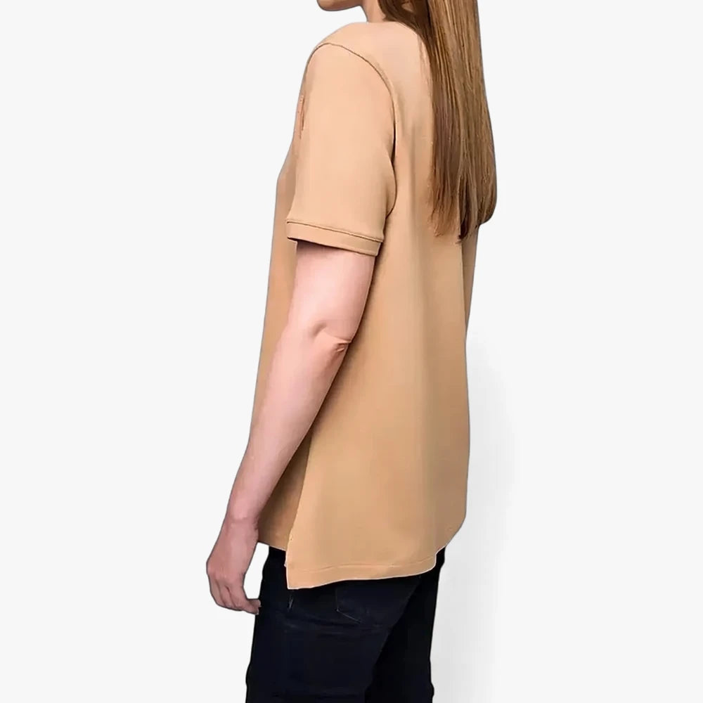 A woman wears a Polo Womens Margot Short Sleeve Golfer in taupe, shown from the side in a studio shot.