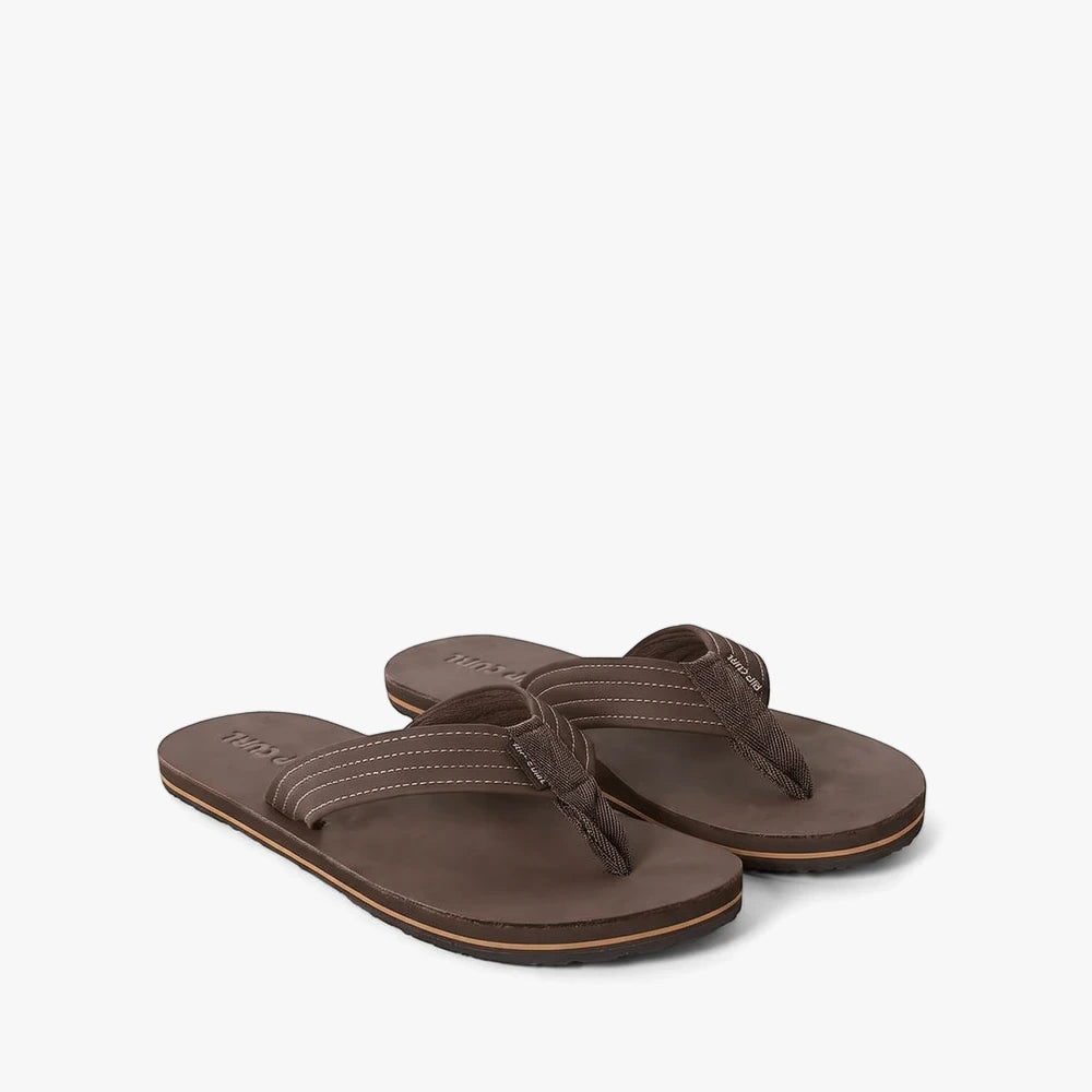 A pair of Ripcurl Mens Revival open-toe sandals in dark brown leather with white stitching, displayed from an angled view.