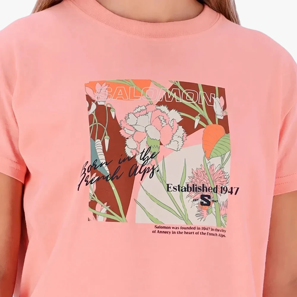 Salomon Womens Freedom Short Sleeve Tee in Murex Shell, a pink t-shirt with a graphic floral print featuring &