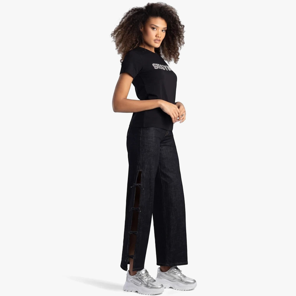 Sissy Boy black regular fit tee with bling lettering, worn by a woman with dark jeans and silver sneakers. Full body.
