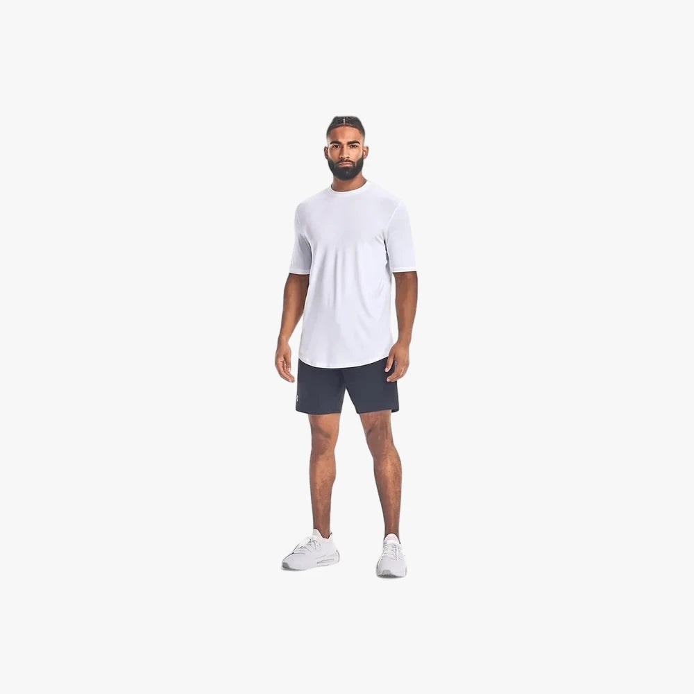 Full body image of a male model wearing Under Armour Mens Unstoppable Shorts 001 Black and a white t-shirt, standing.