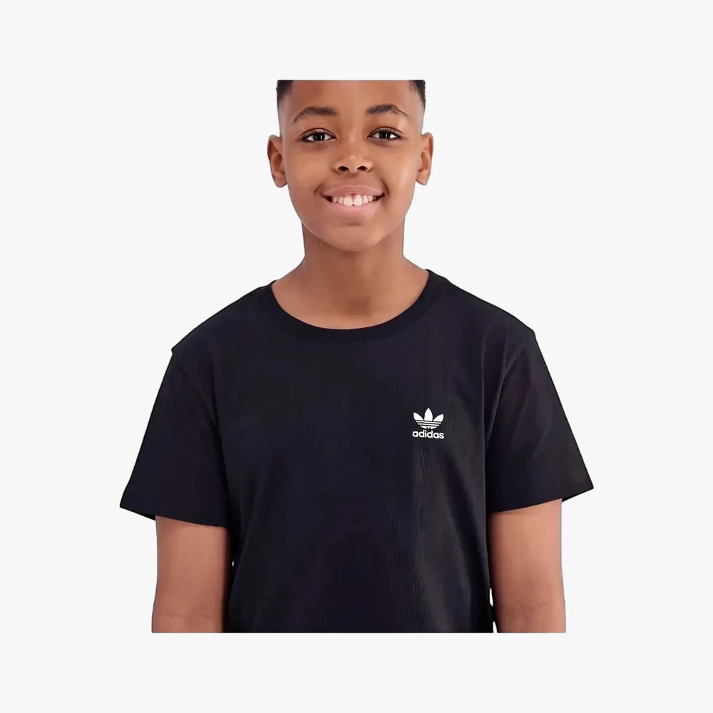 Young boy smiling in a black Adidas Youth Essential short sleeve t-shirt with the white Adidas trefoil logo on the chest.