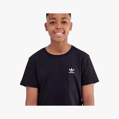 Young boy smiling in a black Adidas Youth Essential short sleeve t-shirt with the white Adidas trefoil logo on the chest.