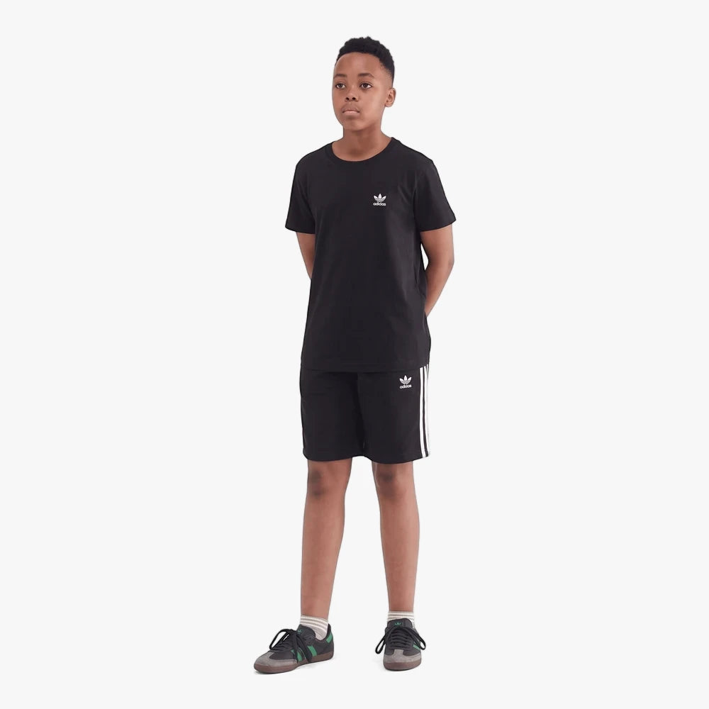 Young boy wearing a black Adidas Youth Essential short sleeve tee and matching black shorts with white stripes, standing