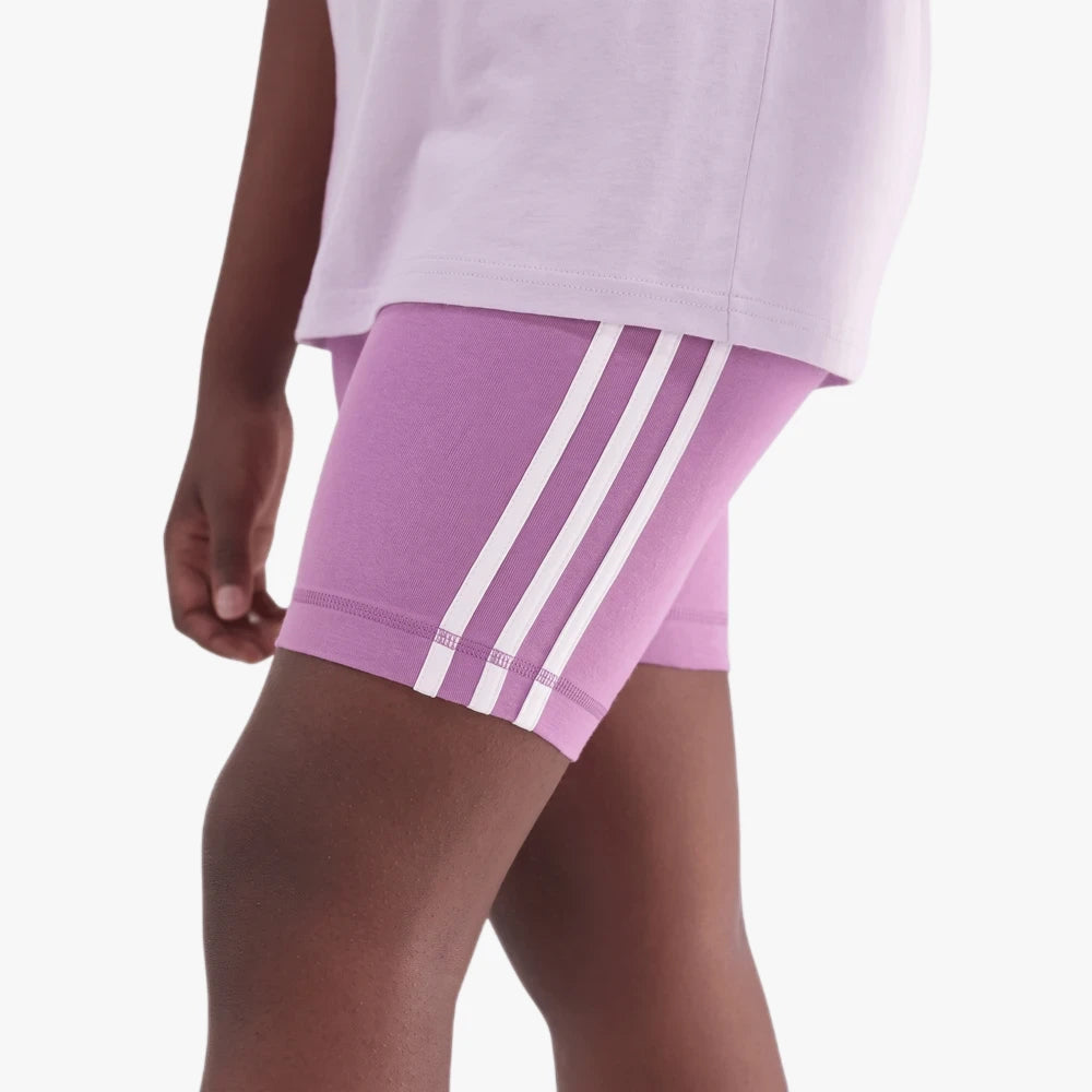 Close-up of Adidas Girls 3S Tigh Shorts in purple with distinctive white three-stripe detailing, worn by a child.