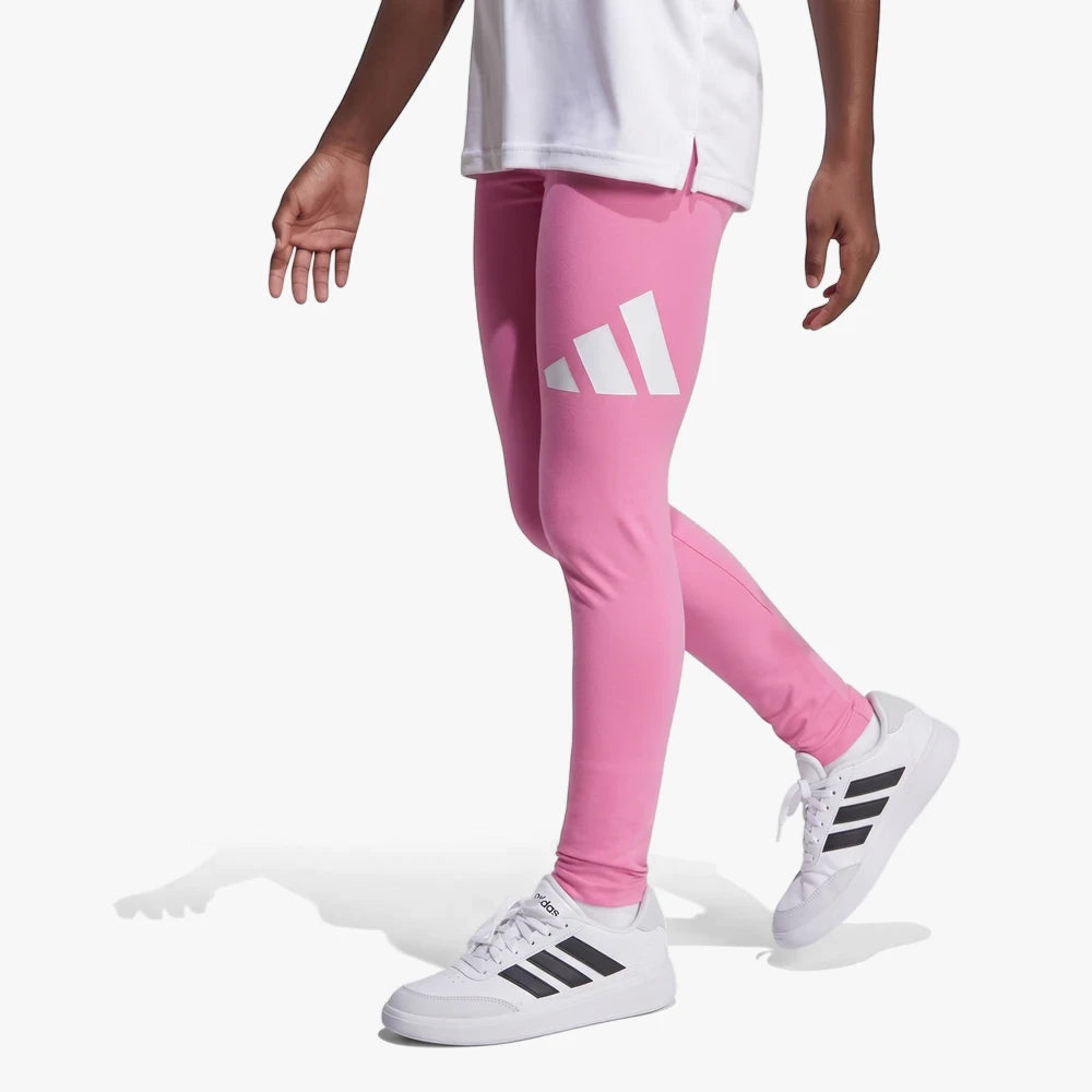 Close-up of a person wearing pink Adidas Girls BL leggings with a white logo, paired with white Adidas sneakers, in a
