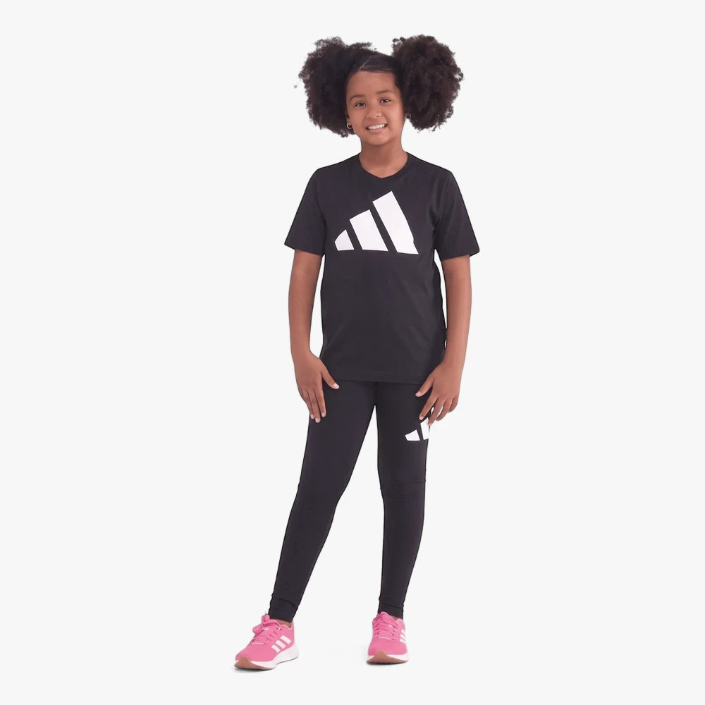 Adidas Girls Black Leggings and black t-shirt set, modeled by a young girl wearing pink sneakers, full body view.