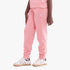 Lower body view of a child wearing pink Adidas girls track pants with a white trefoil logo and white sneakers with brown