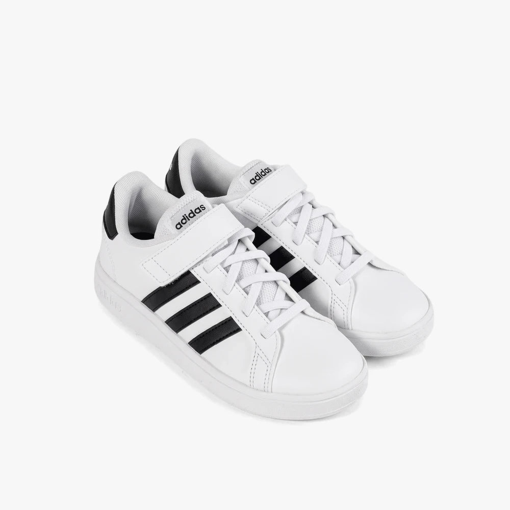 A pair of Adidas Kids Grand Court 2.0 El Sneakers in white with black stripes and velcro straps, viewed from a slightly