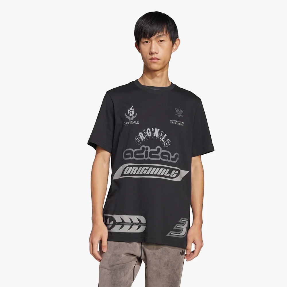 Adidas Mens Q12 Ts Sponsor Tee in black, worn by a model, featuring multiple grey and white graphic logos and details.
