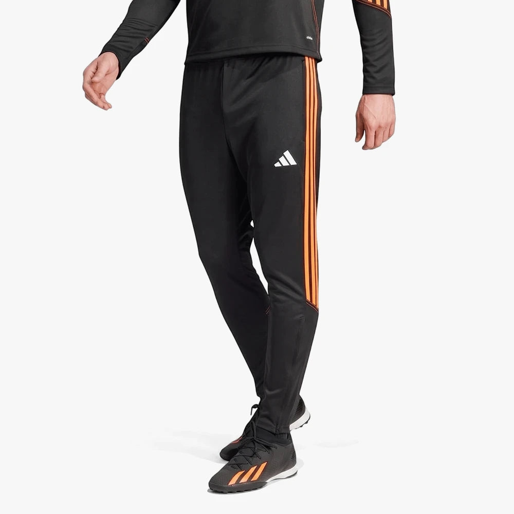 Adidas Mens Tiro23 Trackpants in black with orange stripes, worn by a model in a dynamic pose.
