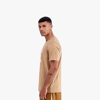 Male model wearing a cardboard color Adidas Mens Tref Short Sleeve Tee with a white Trefoil logo, shown in a side profile