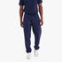 Adidas Mens Trefoil Essentials French Terry Joggers in Night Indigo, worn by a man with a navy t-shirt and white sneakers.