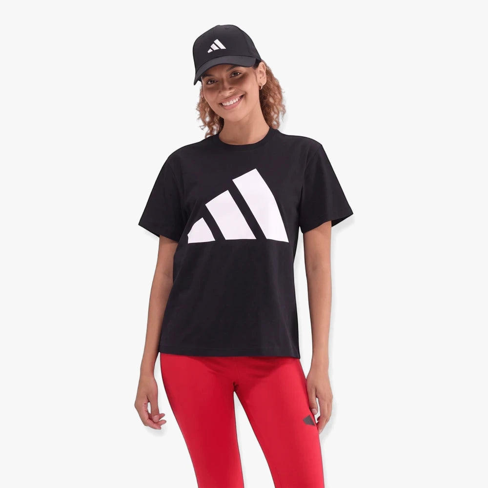 Smiling woman wears an Adidas black t-shirt with a white logo, red leggings, and a black cap.