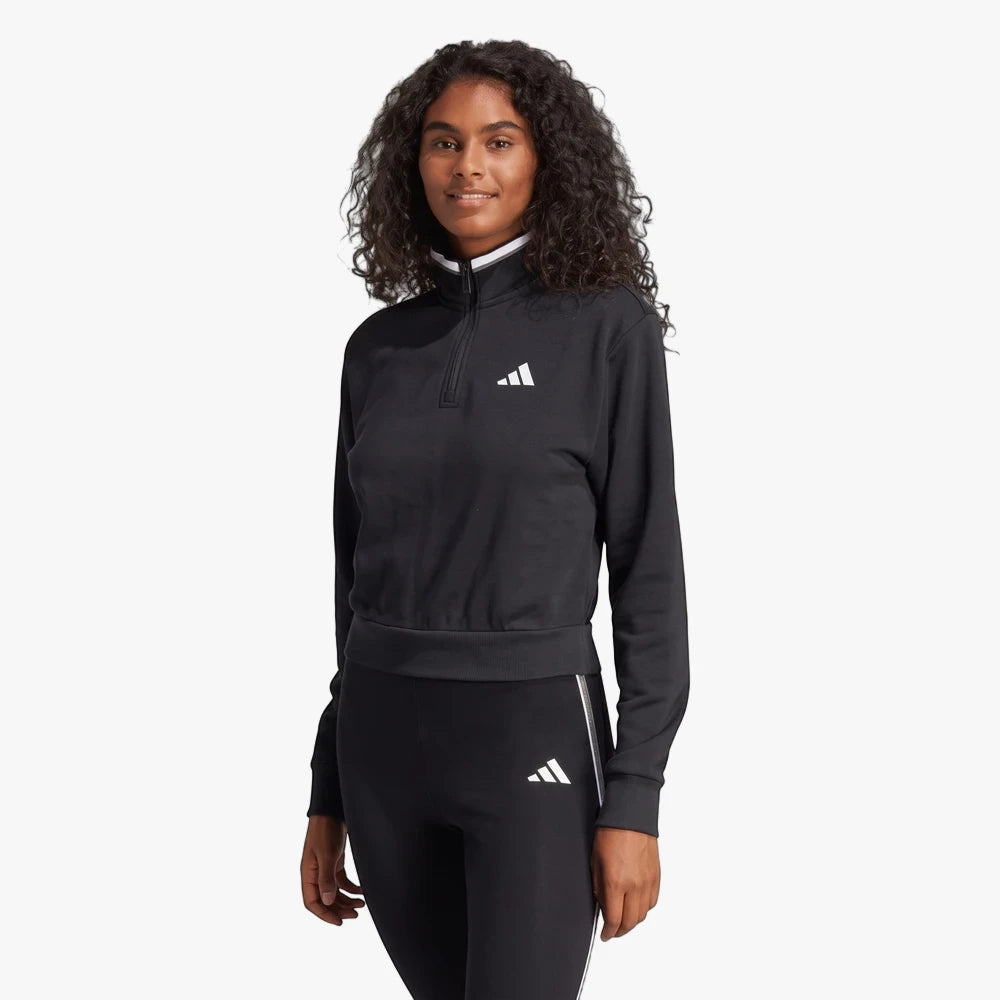 Woman wearing a black Adidas cropped 1/4 zip track jacket with white collar and matching black leggings.