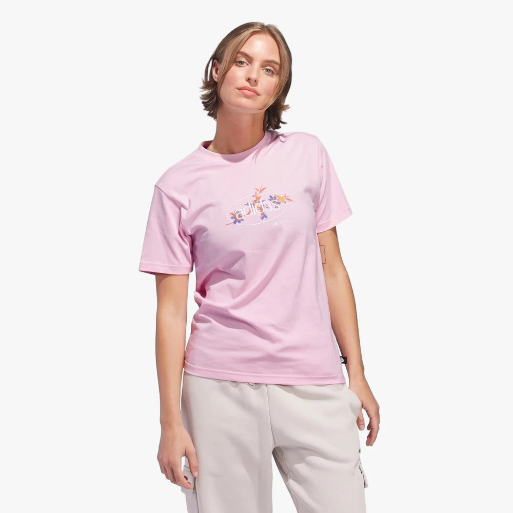 Adidas Womens Elem Flrl Short Sleeve Tee in Clear Pink, featuring a floral graphic and short sleeves, modeled by a woman.