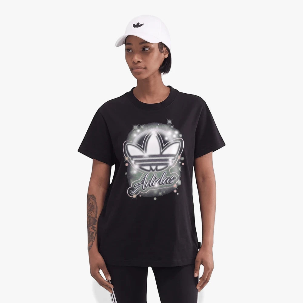 Adidas Womens Spray Short Sleeve Tee in black, featuring a glittery trefoil logo, worn by a woman with a white Adidas cap.