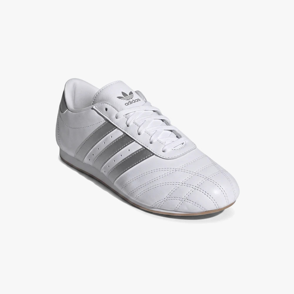 Adidas Womens Taekwondo Lace Sneaker in white with silver stripes and logo, shown from a slightly elevated side view on a