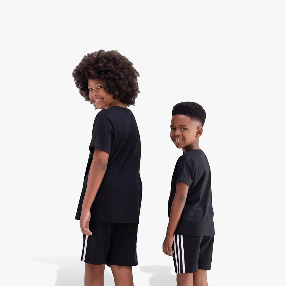 Two young boys in black Adidas Youth Ess Short Sleeve Tees and black shorts with white stripes, smiling, posing in casual