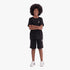 Young boy wearing a black Adidas Youth Ess Short Sleeve Tee and black Adidas shorts with white stripes, with white Adidas