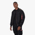 Male model wearing a black Alpha Industries MA-1 Classic bomber jacket over a black t-shirt and black cargo pants, standing.