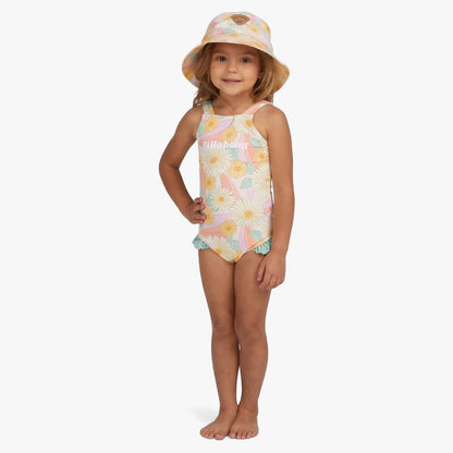 Young girl wearing a Billabong Sweet Sunset one-piece swimsuit in salt crystal with a pastel daisy print and a matching