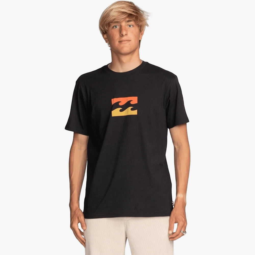 A male model wears a black Billabong Team Wave short sleeve tee with an orange and yellow wave logo.