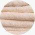 Close-up of fluffy beige Colibri Imperial Zerotwist bath sheets stacked horizontally, showcasing the soft terrycloth texture.