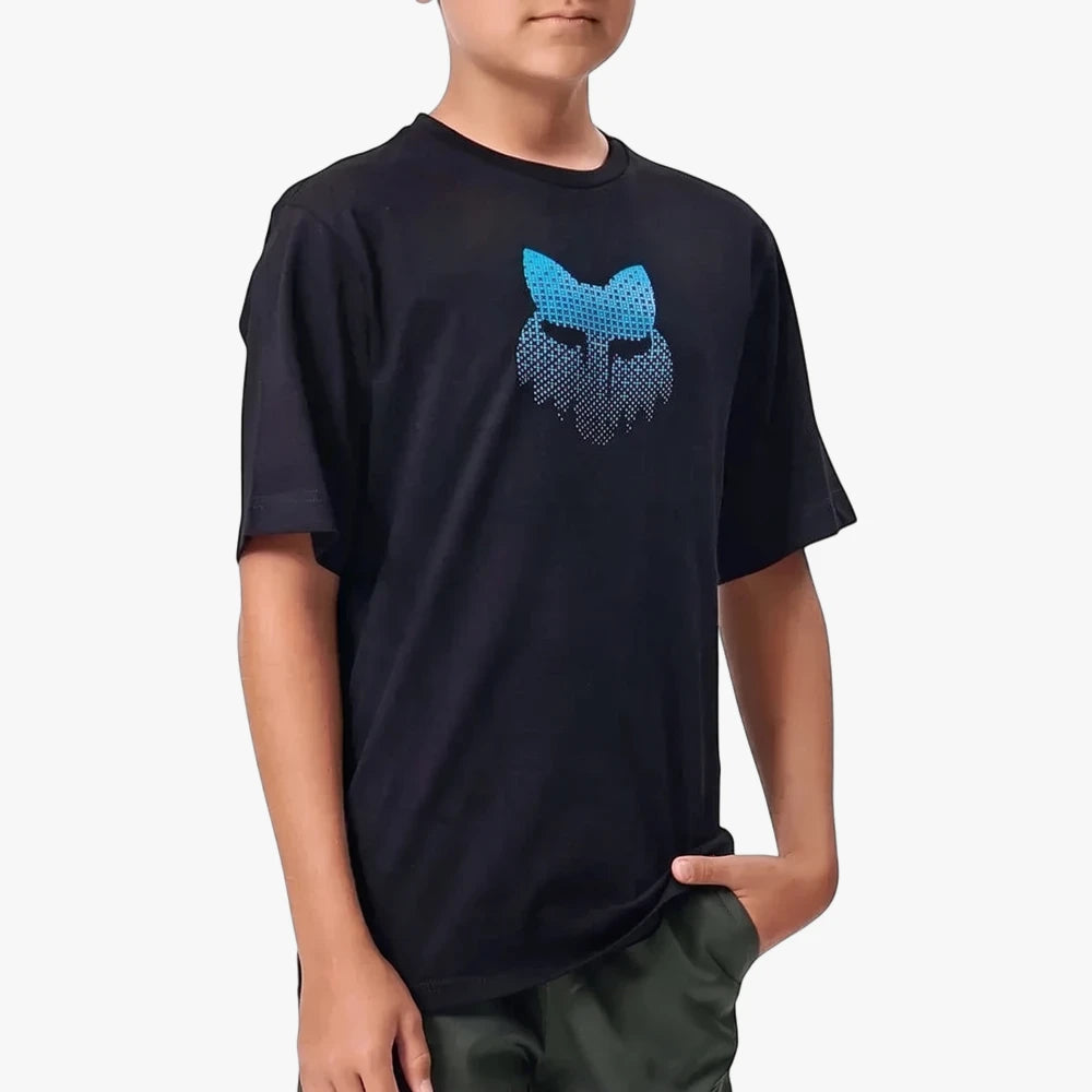 Young boy wearing a black Fox Blur short-sleeve tee with a blue gradient dotted Fox head logo, paired with dark green shorts.