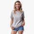 Smiling woman in a light grey heather Fox Womens Absolute Tee and blue denim shorts, showcasing the short-sleeve tee with a