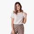 Smiling woman wearing a Fox Womens Aviation Short Sleeve T-shirt in Cloud Dancer white, paired with khaki cargo shorts.