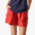Close-up of a woman wearing red Fox Flip Side Cargo Shorts, featuring practical side pockets, captured from the waist down.
