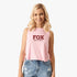 A smiling blonde woman wears a pink Fox Womens Speed Crop Tank Flamingo with a dark red logo, paired with distressed denim