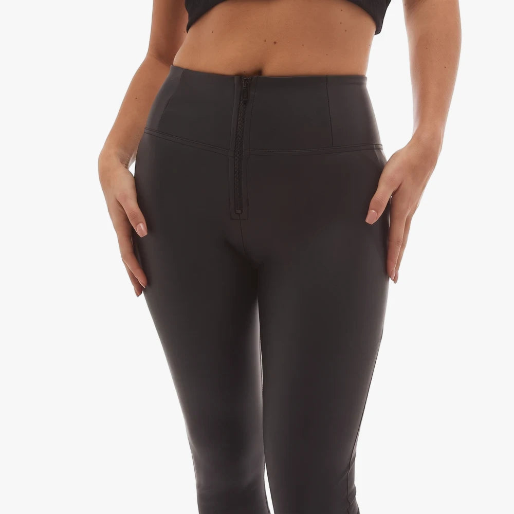 Close-up of a woman wearing black Freddy Wr.Up faux leather high-waist full-length leggings with a front zipper.