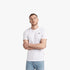 A man models the G Star Mens Basic Short Sleeve Tee in white, paired with light blue jeans. He stands with arms crossed,