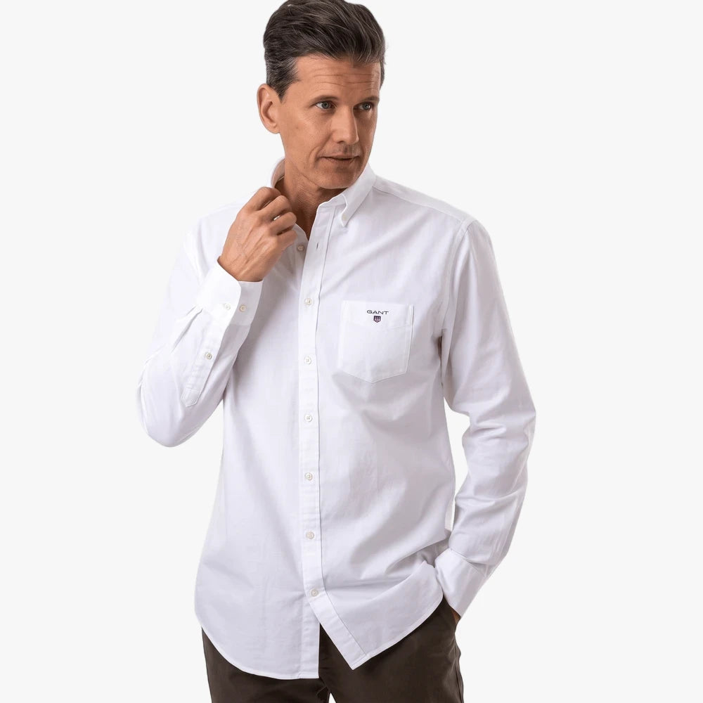 Man wearing a white Gant Regular Fit button-down long sleeve shirt with a chest pocket, looking to the side.