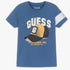 Guess Boys blue short sleeve t-shirt featuring a cap logo graphic and text, displayed flat.