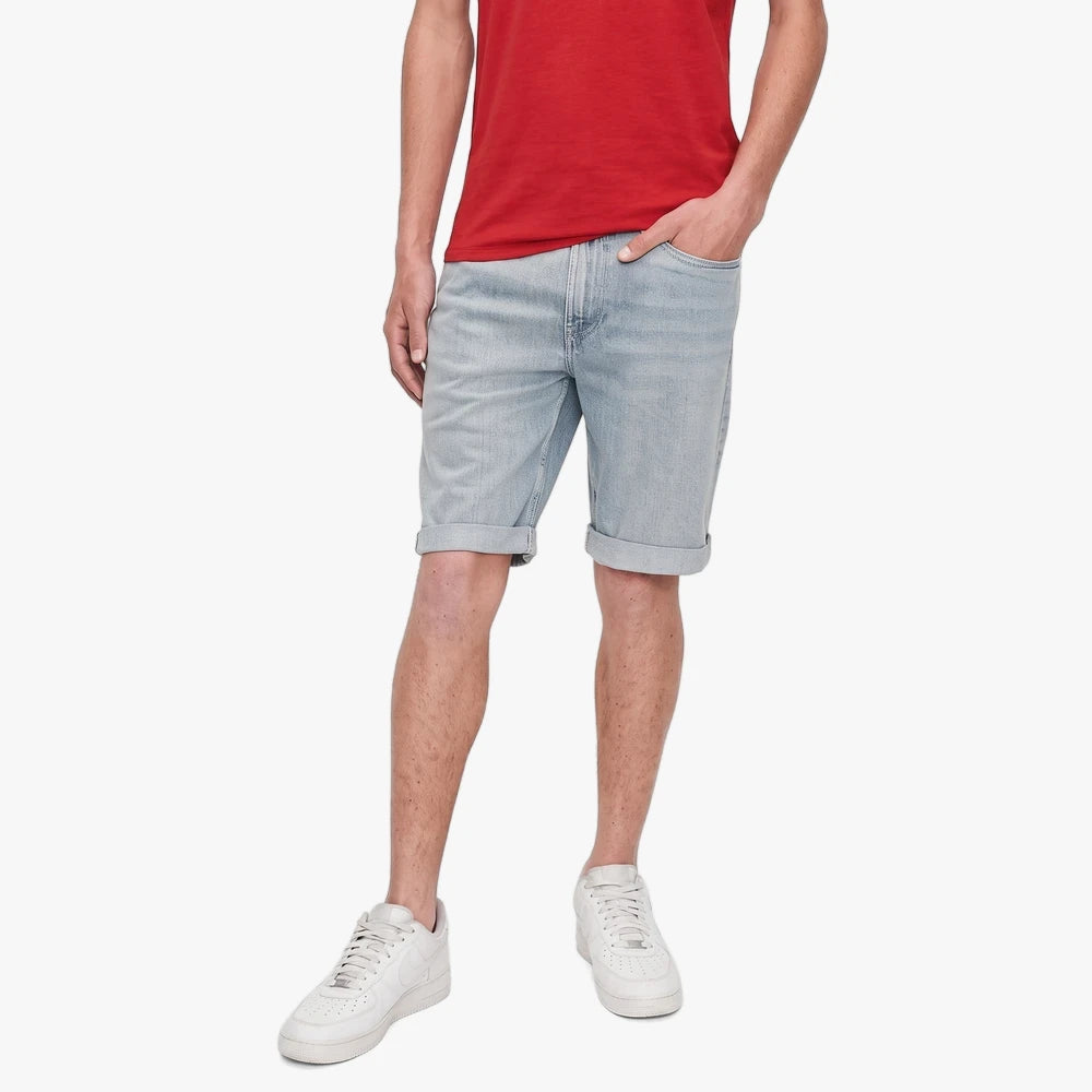 Guess Mens Sandoval Light Wash Denim Shorts worn by a man, paired with a red t-shirt and white sneakers.