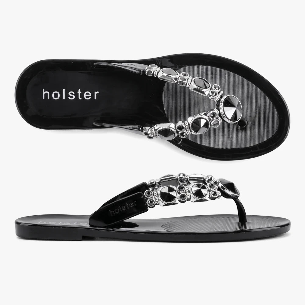 A pair of black Holster Womens Glam Sandals with sparkling embellished straps, shown in both a top-down flat lay and an