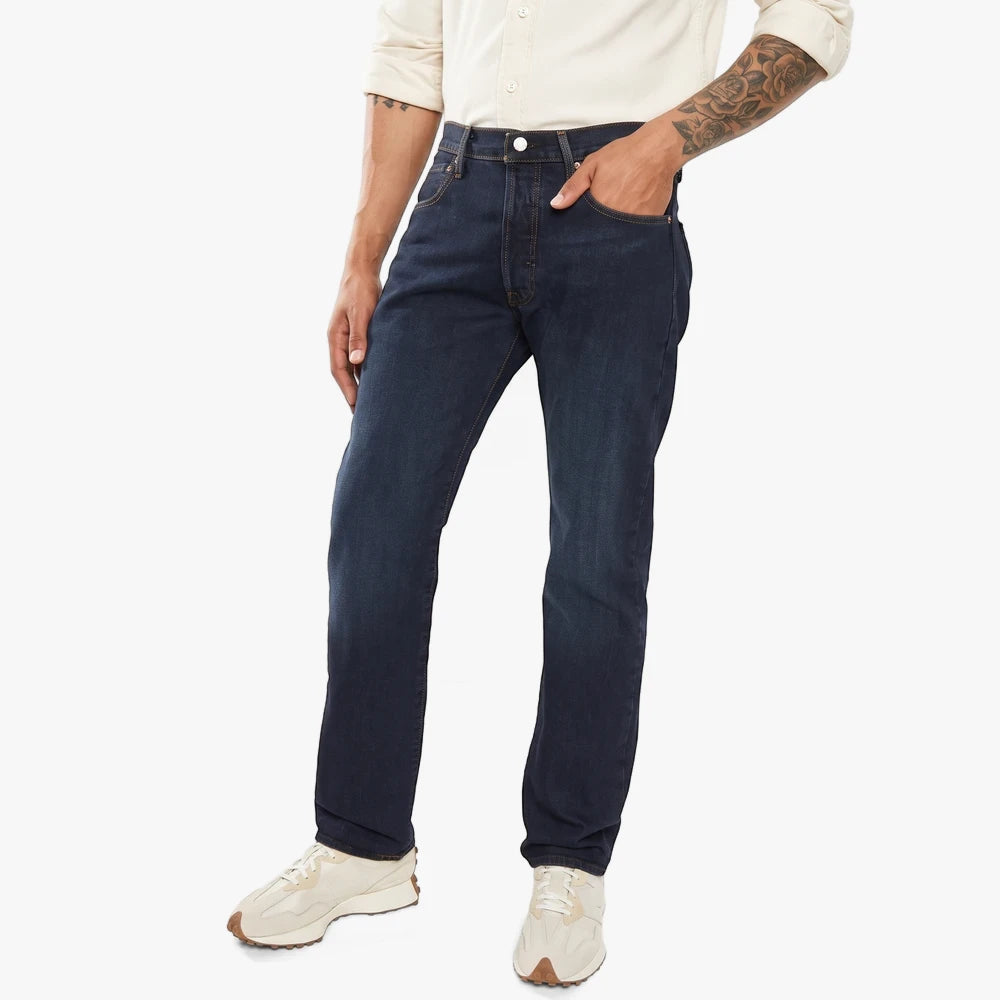 Man wearing dark blue Levis 501 Original Cut Night Hours straight-leg jeans with light sneakers.