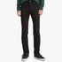 Full body shot of a man wearing Levis Mens 510 Skinny Stretch Jeans in Native Cali black, paired with a green shirt and