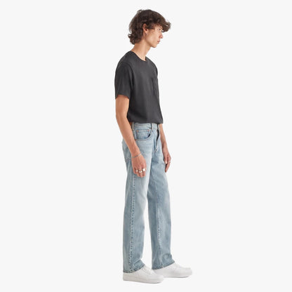 Male model wearing a dark grey t-shirt and Levis Mens 517 Bootleg Jeans in Its All Fun Stonewash, with white sneakers.